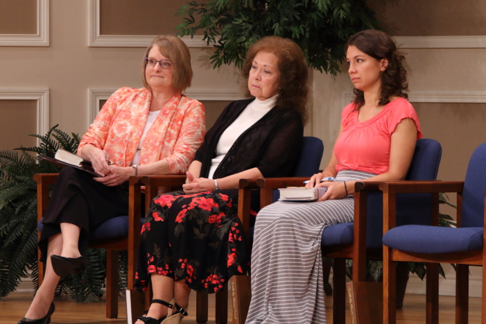 Beth Bartlett, Rita Braeshear, and Sara Reichert listening to Anna Quigley share her testimony.